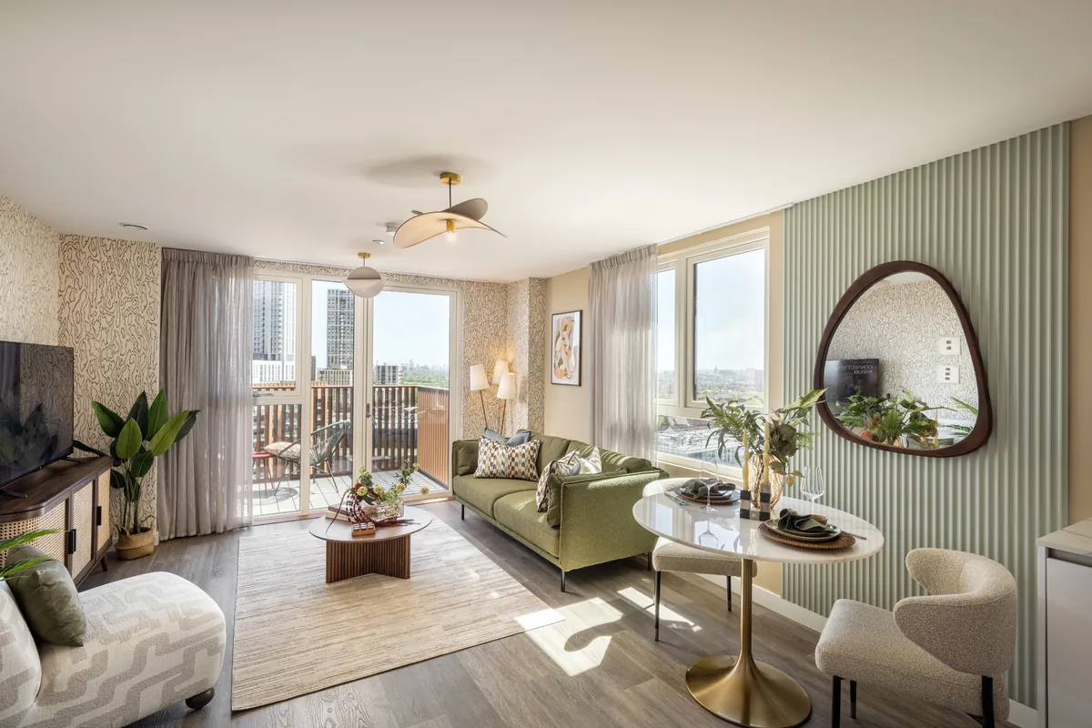 Royal Gateway show home living room with sofa, dining table and balcony door