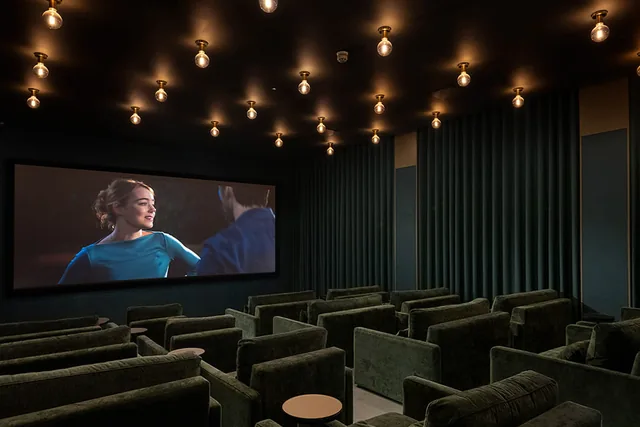 Rows of seats facing the screen in the residents’ cinema at Bow Green