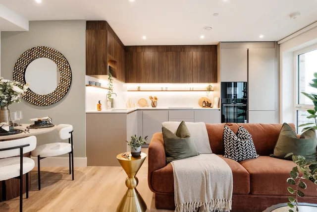 One-bedroom show home at Bow Green: sofa in the living area with the kitchen behind