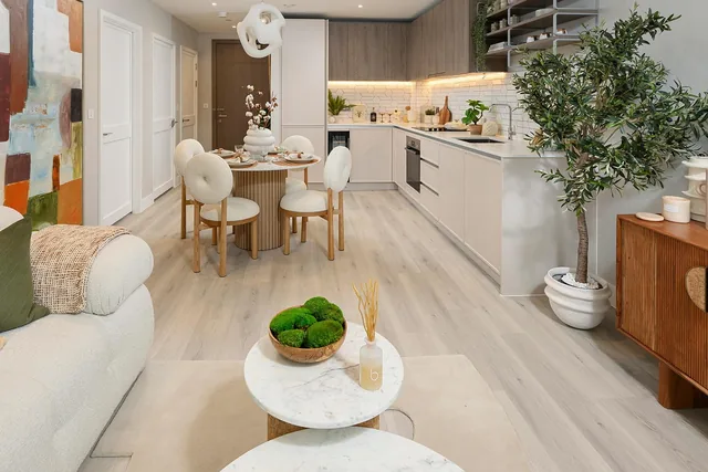 Kidbrooke Village’daki Waterlily Court’ta bir dairenin açık planlı salonu, yemek masası ve mutfağı.