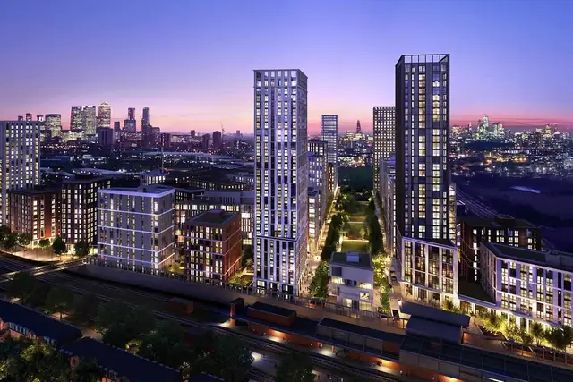 An evening aerial view of the TwelveTrees Park towers beside a railway line, with the London skyline in the distance.