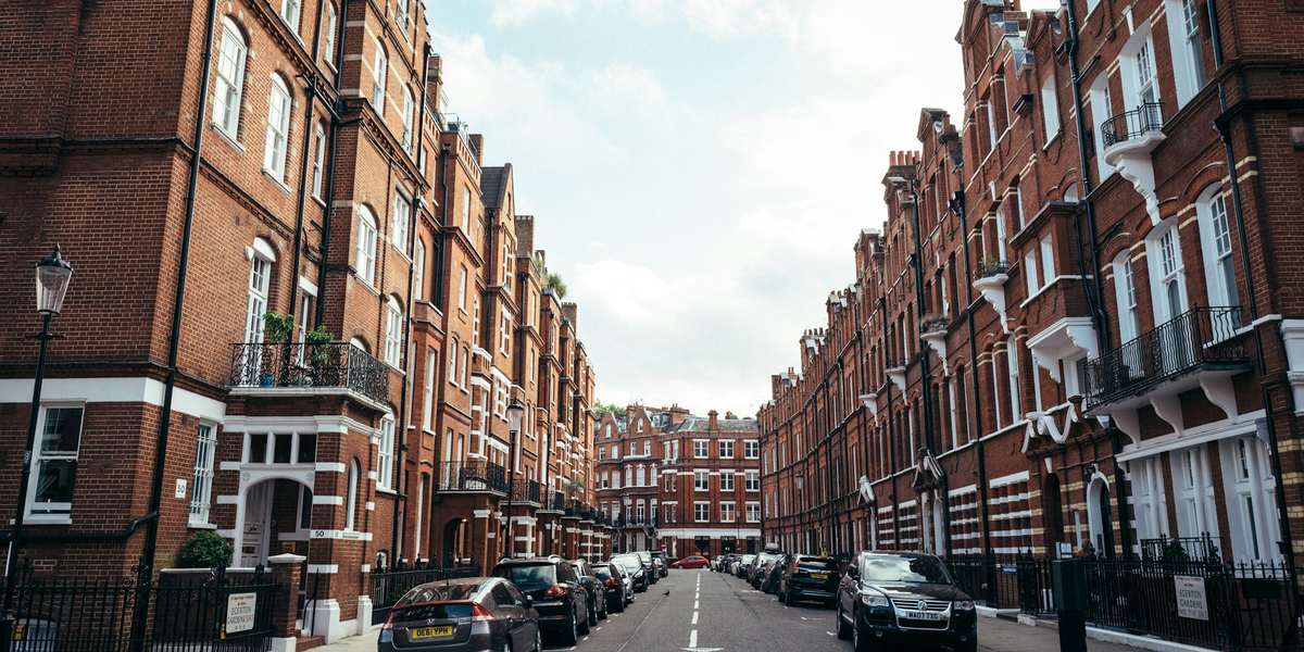 A street lined with tall red-brick blocks of flats