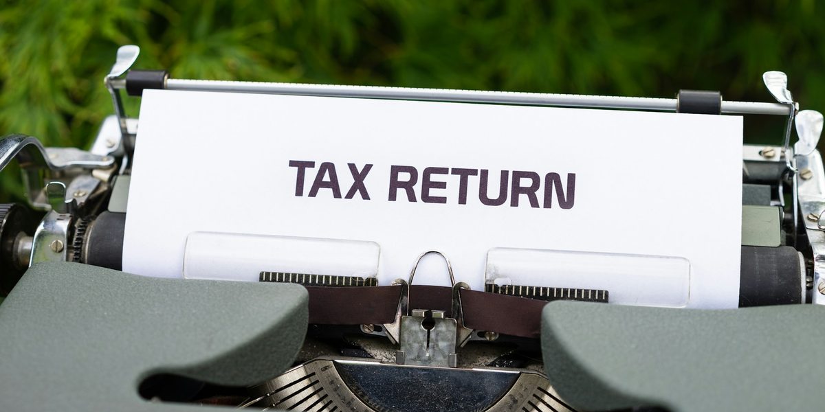 A typewriter with a sheet of paper reading Tax return