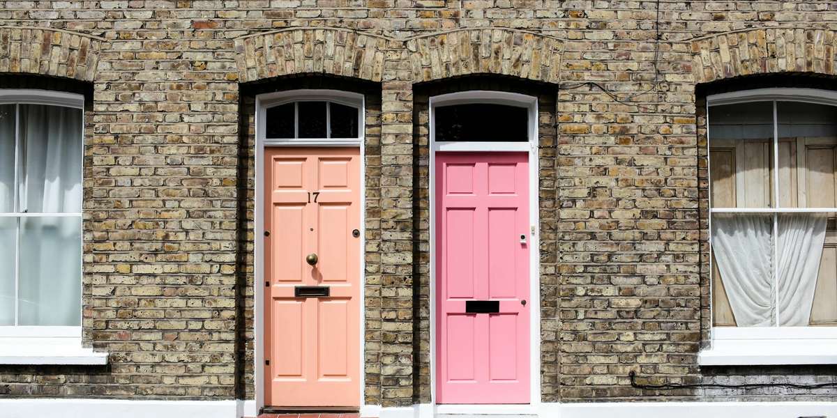 Two pink front doors side by side in a brick terrace